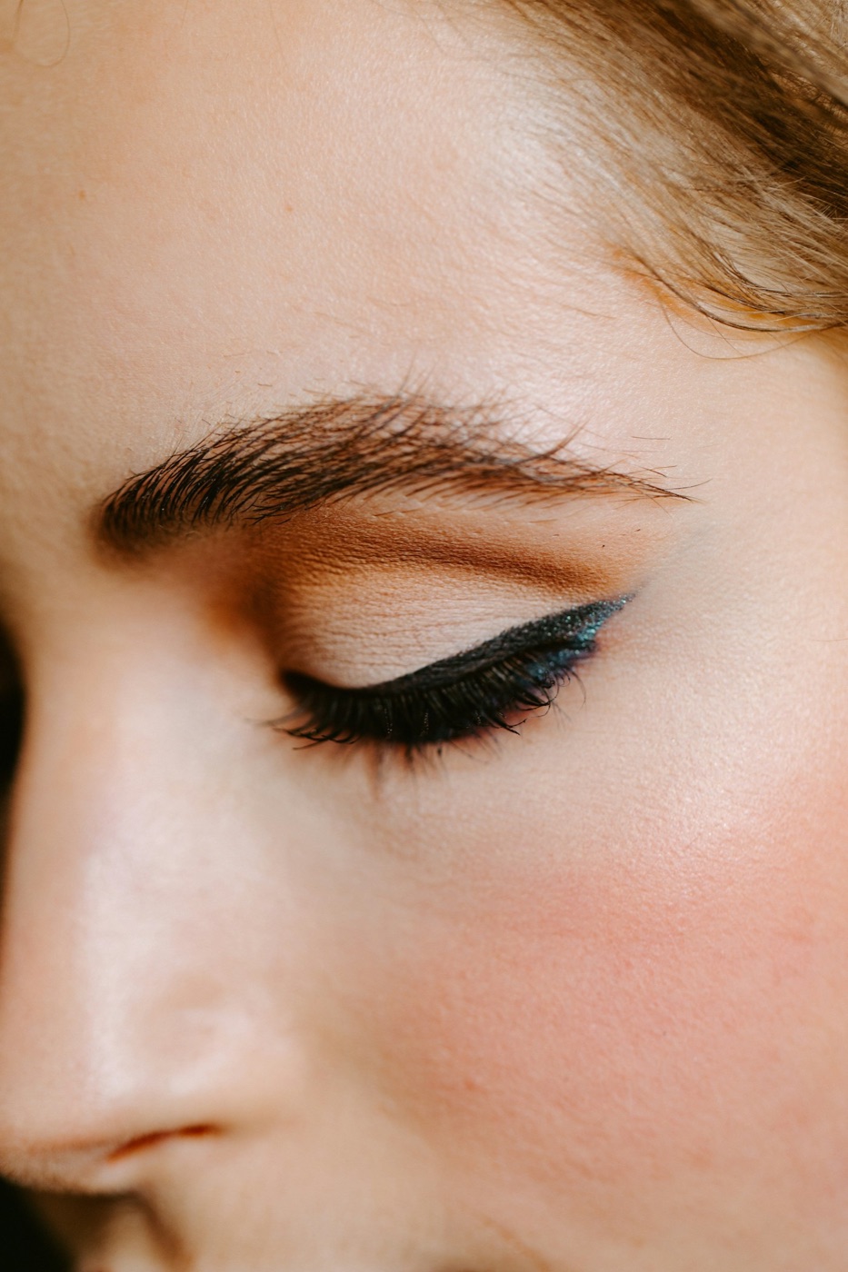 Primer plano del ojo cerrado de una mujer con cejas diseñadas y pestañas largas
